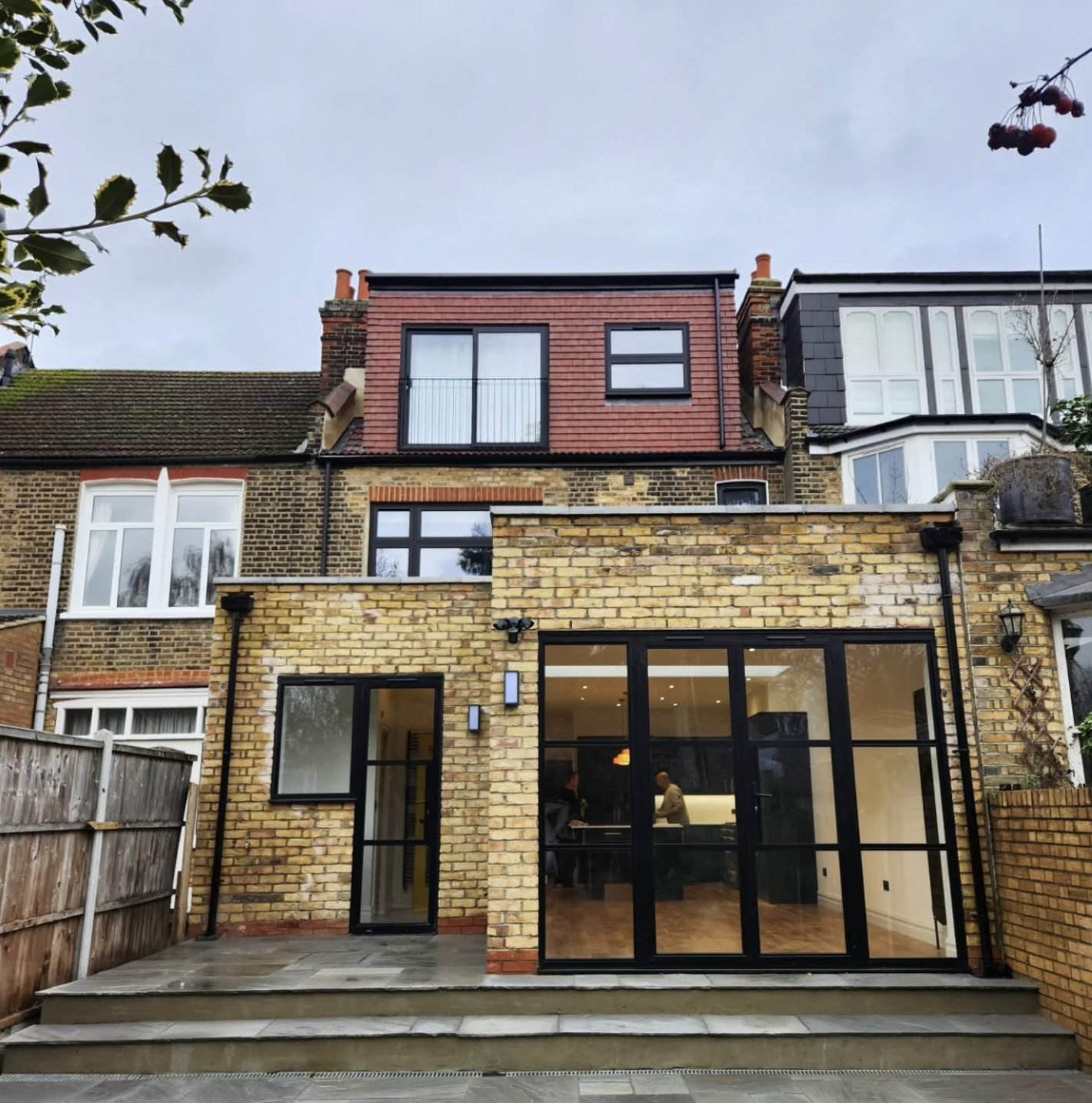 Victorian terrace with a red tile-hung rear dormer and Juliet balcony rail above a yellow stock brick extension